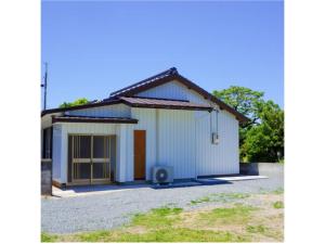 a small white building with a door in a driveway at Pensione Shimado - Vacation STAY 37555v in Shimonoseki
