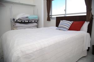 a bedroom with a large white bed and a window at Guest room WES - Vacation STAY 54452v in Uruma