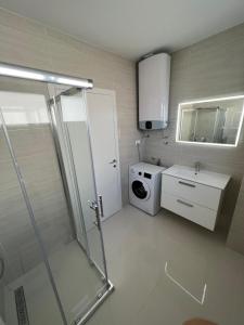 een badkamer met een douche en een wasmachine bij Residence Doli in Vrsi