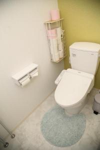a bathroom with a white toilet and a blue rug at Guest room WES - Vacation STAY 54452v in Uruma