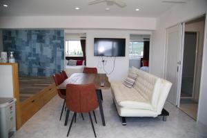 a living room with a table and a white couch at Guest room WES - Vacation STAY 54452v in Uruma