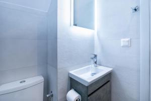 a white bathroom with a sink and a toilet at Fontana Di Corfu 4 in Corfu Town