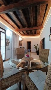 een eetkamer met een glazen tafel en rieten stoelen bij Casa Buzones in Toledo