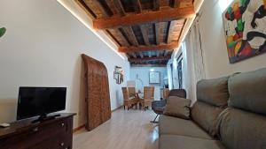 een woonkamer met een bank en een flatscreen-tv bij Casa Buzones in Toledo