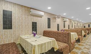uma sala de jantar com mesas, cadeiras e espelhos em SY Elite Residency em Hyderabad