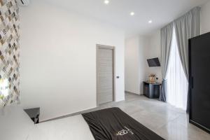 a white room with a bed and a television at Red Queen Naples in Naples