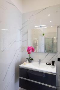 a bathroom with a sink and a mirror at Red Queen Naples in Naples +42 photos