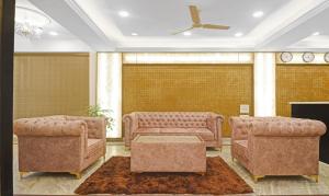 uma sala de estar com duas cadeiras e um sofá em SY Elite Residency em Hyderabad