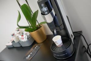 a coffee machine sitting on a table with a coffee cup at Red Queen Naples in Naples