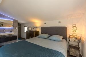 a bedroom with a large bed and a sink at Casa Dina in Sommières