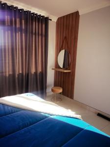 1 dormitorio con cama azul y espejo en 1205OnTheGoldenMile - 4 Sleeper Ocean View with Pool & Braai at 10 South en Durban