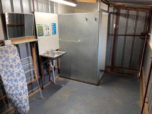 ein kleines Bad mit einem Waschbecken und einer Tür in der Unterkunft Shearers Quarters - The Dutchmans Stern Conservation Park in Quorn