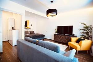 un soggiorno con divano blu e TV di ZÓRA APARTMAN a Eger