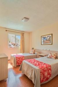 a hotel room with two beds and a window at Apartamentos las Góndolas in Playa del Ingles