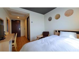 1 dormitorio con cama blanca, mesa y silla en ｂｕｓｉｎｅｓｓ&ａｃｔｉｖｉｔｙ ｃｈａｎｖｒｅ - Vacation STAY 64311v, en Tochigi