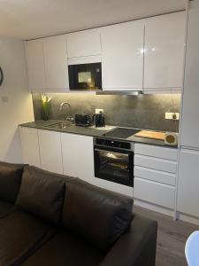 un salon avec un canapé dans une cuisine dans l'établissement Lovely 3 bed ground floor flat with free parking, à Swanage