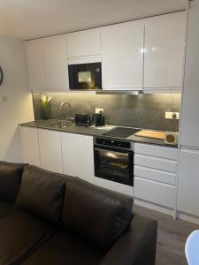 a living room with a couch in a kitchen at Lovely 3 bed ground floor flat with free parking in Swanage