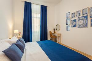 Schlafzimmer mit einem blauen und weißen Bett und einem Fenster in der Unterkunft Apartman Lussi in Pula