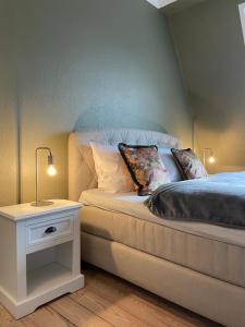 - un lit avec deux oreillers et une table de chevet à côté dans l'établissement Schöne große 4 Zimmer-Altbauwohnung, à Kiel