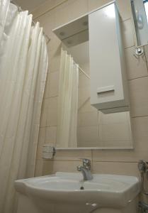 een badkamer met een wastafel en een spiegel bij Three Palms Apartments Novakovic in Petrovac na Moru