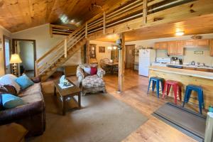 uma sala de estar com um sofá e uma cozinha em Burns Lake Cabin with Dock, Fire Pit, Rowboat and More em Little Round Lake