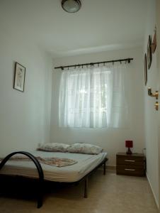 een slaapkamer met een bed met een wit gordijn bij Three Palms Apartments Novakovic in Petrovac na Moru
