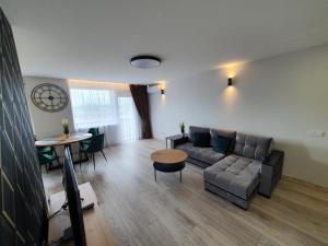 ein Wohnzimmer mit einem Sofa und einem Tisch in der Unterkunft 2-bedrooms apartment in city center Šiauliai in Šiauliai