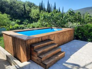 a swimming pool with a wooden deck and stairs around it at Private Countryside House Three Figs in Gruda