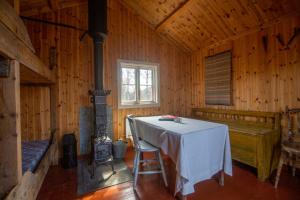 a dining room with a table in a wooden cabin at Unique cabin Sikringsbua in Sirdal in Tjørhom