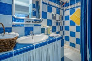 uma casa de banho azul e branca com um lavatório e um espelho em Clos des Hérissons - Chambres - Piscine & jardin em Lauris