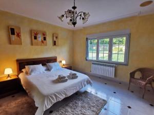 a bedroom with a large bed and a window at Casa da Pioxa in Camariñas