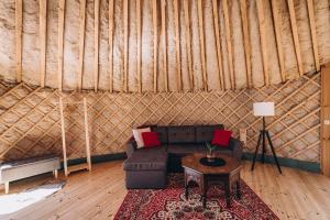 a living room with a couch and a table in a yurt at VasaRojaus Jurta in Birštonas