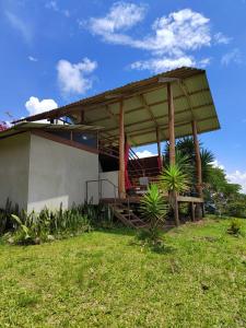 una casa con un pabellón en un campo de hierba en Hacienda Monteclaro, en Turrialba
