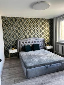a bedroom with a large bed and two tables at 2-bedrooms apartment in city center Šiauliai in Šiauliai