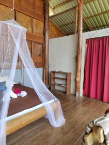 a bedroom with a bed with a mosquito net at Hacienda Monteclaro in Turrialba