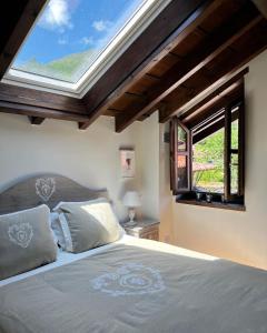 a bedroom with a large bed with a skylight at La casita de Olivia Espinaredo in La Villa