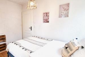 a white bedroom with a bed and a chandelier at Apartment Kerbholz - zwischen Südschwarzwald und Schweiz in Klettgau