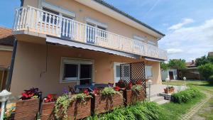 una casa con un balcón con flores. en Apartment in Zamardi/Balaton 20348 en Zamárdi