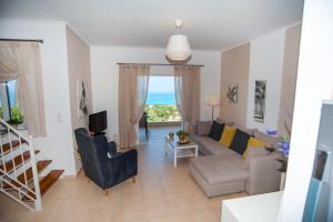 sala de estar con sofá, mesa y TV en Nicopolis Villa1, en Vrachos