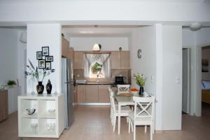 cocina y comedor con mesa y sillas en Nicopolis Villa1, en Vrachos