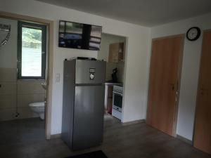 a kitchen with a stainless steel refrigerator and a toilet at Bungalow Matilda in Lauchhammer