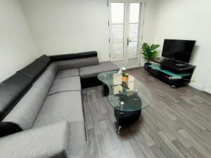 sala de estar con sofá y mesa de cristal en Le Maclaren - Circuit 24H - 6p en Le Mans