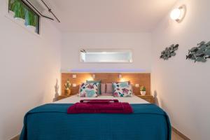 sypialnia z dużym łóżkiem z niebieską pościelą i poduszkami w obiekcie Quality and peaceful stay in Playa del Inglés w mieście Playa del Ingles