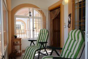 2 sillas verdes y blancas en una habitación con ventana en Apartamento Río Támesis by Rental Olé, en Torrevieja