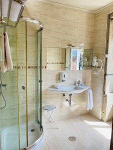 uma casa de banho com um chuveiro e um lavatório. em Residencial Portas do Sol em Valença