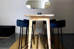 a table with two blue stools and a mirror at 119 LOFT DONCELES CENTRO HISTÓRICO CDMX in Mexico City