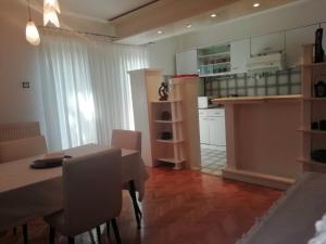 a kitchen and dining room with a table and chairs at Pine Apartment in Gevgelija