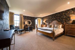 a bedroom with a bed and a desk in a room at Gleddoch Golf & Spa Resort in Langbank