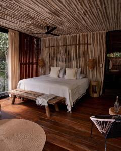um quarto com uma cama e um tecto em madeira em Kapok Bacalar - Plant Based Hotel em Buenavista