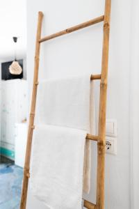 a towel rack with white towels hanging on it at Anna's Apartments in Mikonos